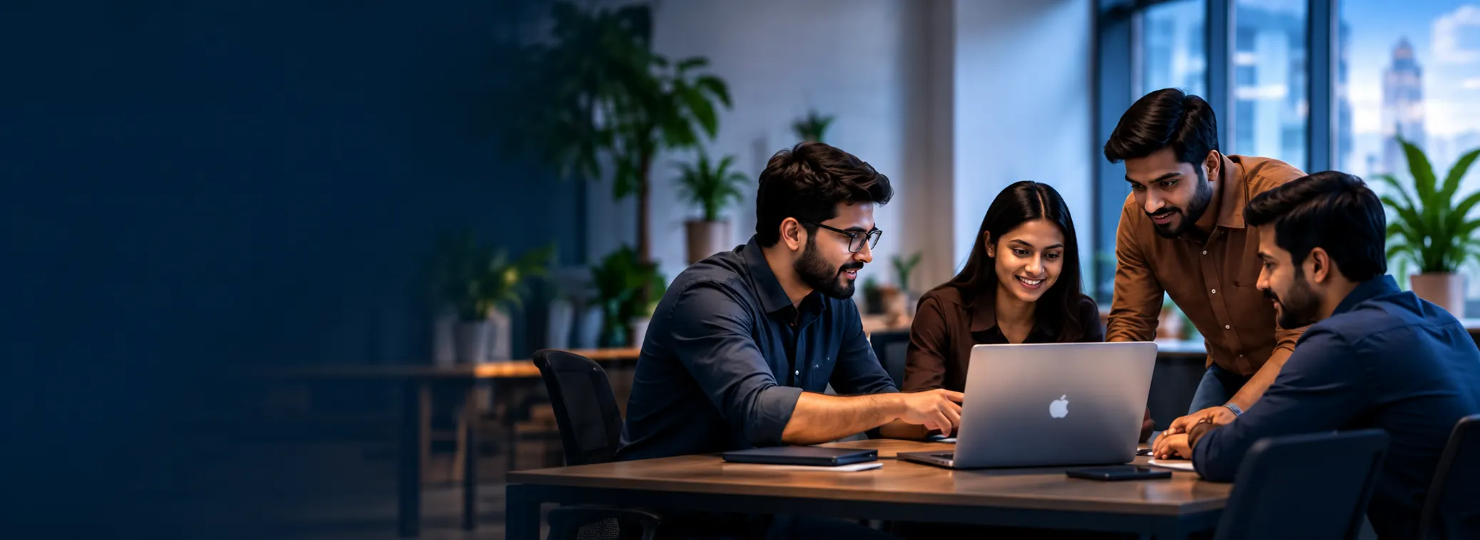 A team reviewing a project together on a laptop